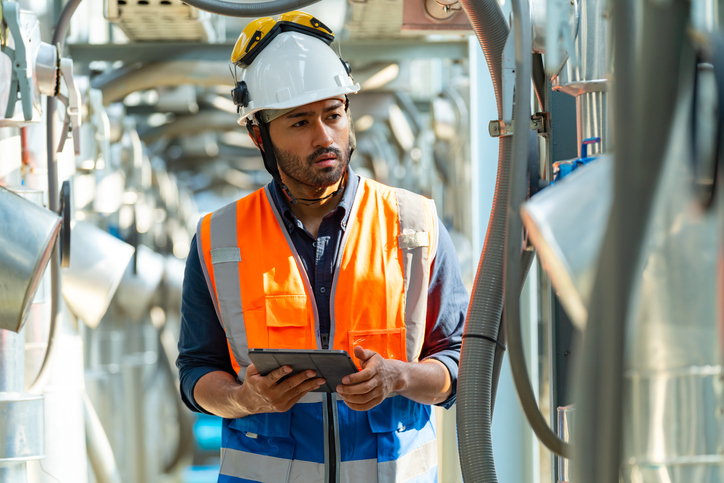 Facilities technician inspecting equipment with a QR workflow